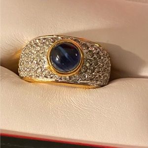 Oval cabochon sapphire and surrounded by tapered baguette